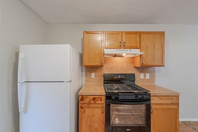 20027 Oland Way, Houston, TX 77073 - kitchen featuring freestanding refrigerator, black range with gas cooktop, under cabinet range hood, and light countertops