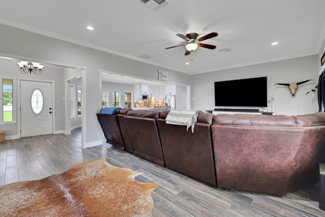 6202 Oleander Dr, Baytown, TX 77523 - living room with light wood finished floors, ceiling fan, recessed lighting, ornamental molding, and a chandelier