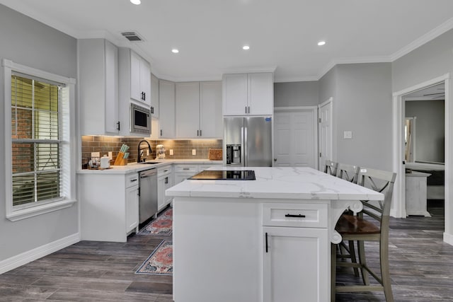 6202 Oleander Dr, Baytown, TX 77523 - kitchen with appliances with stainless steel finishes, a breakfast bar area, a center island, backsplash, and recessed lighting