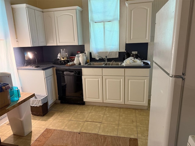 906 E Houston Ave, Crockett, TX 75835 - kitchen with freestanding refrigerator, dishwasher, dark countertops, and white cabinetry
