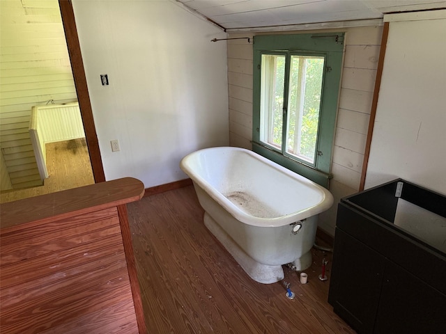 906 E Houston Ave, Crockett, TX 75835 - full bathroom with wood walls, a freestanding bath, and wood finished floors