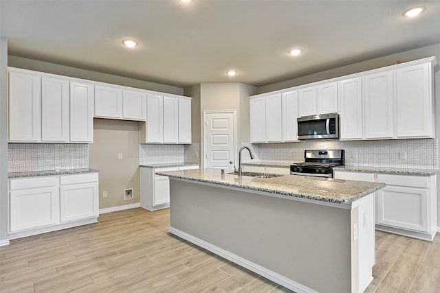160 Majestic Shores Ln, La Porte, TX 77571 - kitchen featuring appliances with stainless steel finishes, decorative backsplash, a kitchen island with sink, white cabinetry, and recessed lighting