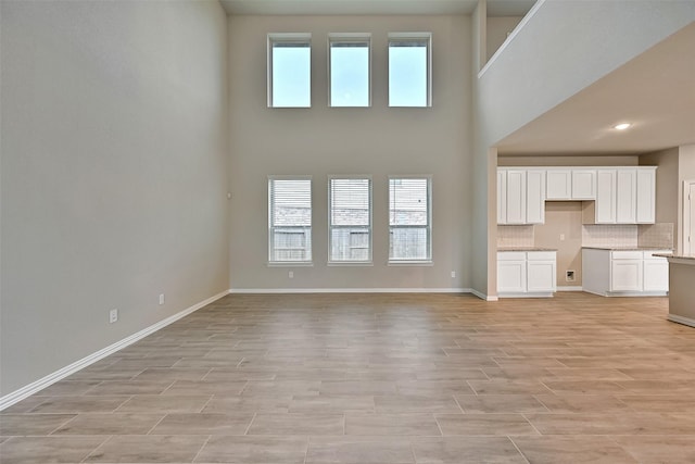 160 Majestic Shores Ln, La Porte, TX 77571 - unfurnished living room with light wood-style floors and a towering ceiling
