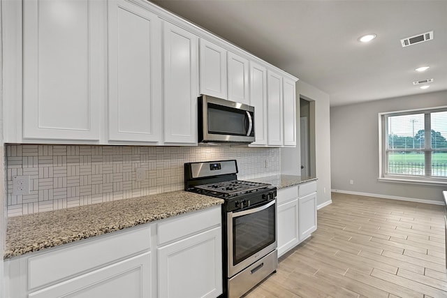 160 Majestic Shores Ln, La Porte, TX 77571 - kitchen featuring stainless steel appliances, decorative backsplash, white cabinetry, light stone countertops, and recessed lighting