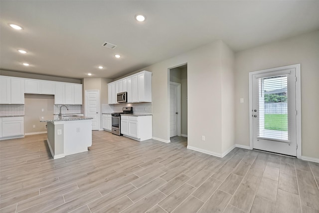160 Majestic Shores Ln, La Porte, TX 77571 - kitchen with appliances with stainless steel finishes, decorative backsplash, light stone counters, light wood-style flooring, and recessed lighting