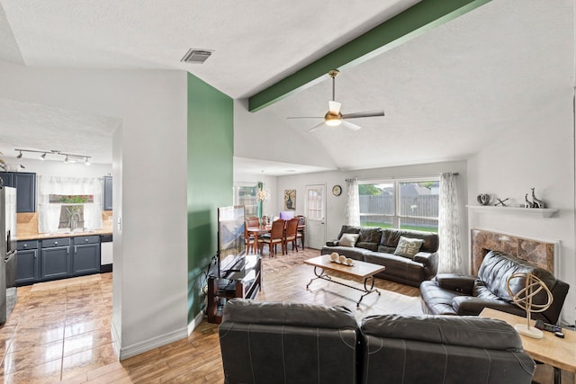 1126 Heathfield Dr, Channelview, TX 77530 - living area with a ceiling fan, a textured ceiling, a fireplace, light wood-type flooring, and track lighting