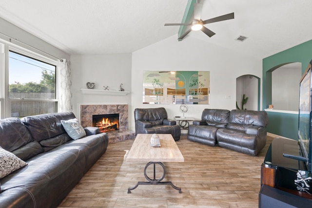 1126 Heathfield Dr, Channelview, TX 77530 - living area with wood finished floors, a ceiling fan, arched walkways, and a warm lit fireplace