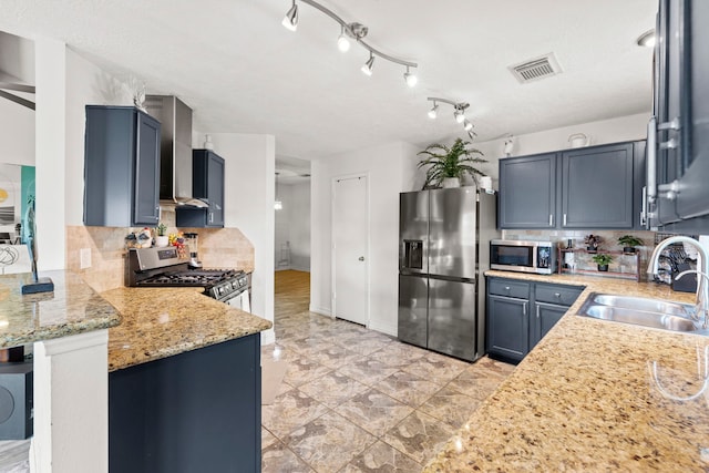1126 Heathfield Dr, Channelview, TX 77530 - kitchen featuring appliances with stainless steel finishes, wall chimney exhaust hood, backsplash, light stone counters, and a peninsula