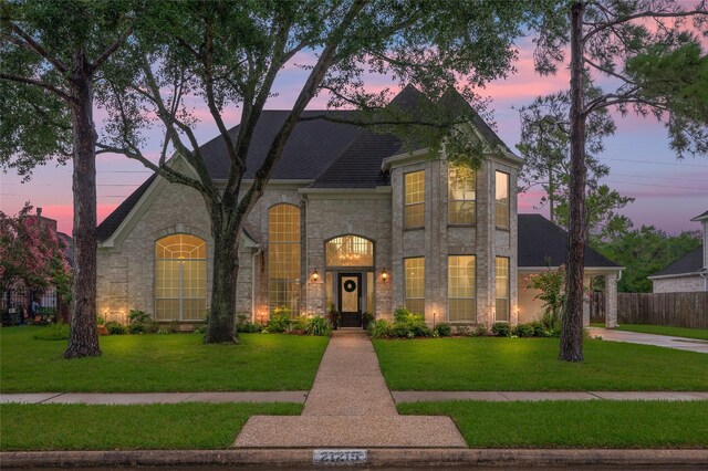 21215 Kelliwood Greens Dr, Katy, TX 77450 - french provincial home featuring stone siding, roof with shingles, and driveway