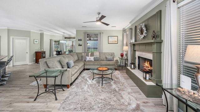 21215 Kelliwood Greens Dr, Katy, TX 77450 - living area featuring light wood finished floors, ornamental molding, a ceiling fan, and a high end fireplace