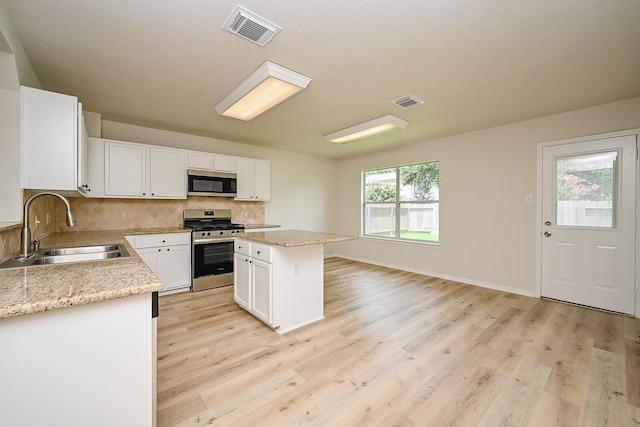 2046 Grand Park Dr, Missouri City, TX 77489 - kitchen featuring stainless steel appliances, light wood-style flooring, and white cabinetry