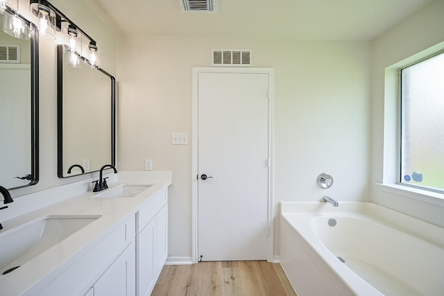 2046 Grand Park Dr, Missouri City, TX 77489 - full bathroom featuring wood finished floors, double vanity, and a bath