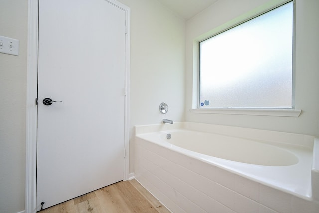 2046 Grand Park Dr, Missouri City, TX 77489 - bathroom featuring a garden tub and wood finished floors