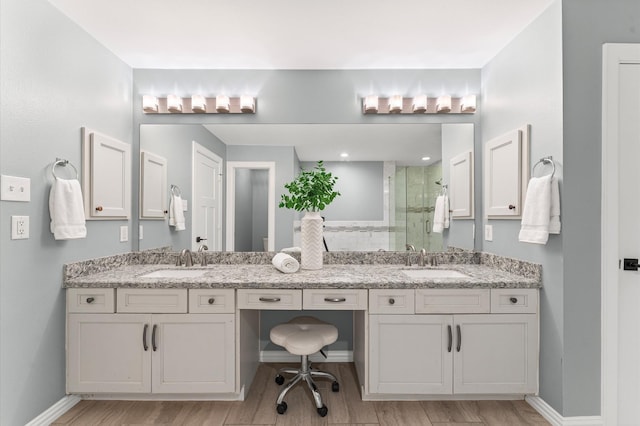 4303 Jonathan St, Bellaire, TX 77401 - bathroom with a shower stall, double vanity, and wood finished floors