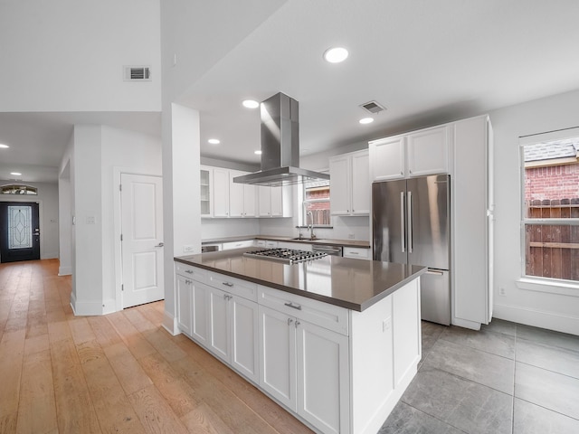 28111 Harper Creek Ln, Katy, TX 77494 - kitchen with island exhaust hood, stainless steel appliances, dark countertops, healthy amount of natural light, and recessed lighting
