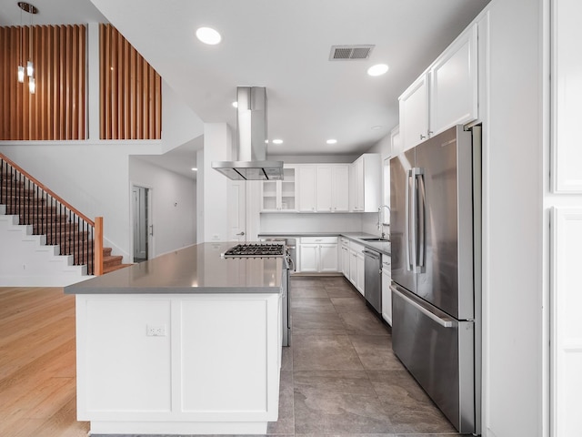 28111 Harper Creek Ln, Katy, TX 77494 - kitchen with appliances with stainless steel finishes, island exhaust hood, a kitchen island, white cabinets, and recessed lighting