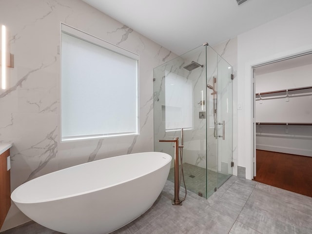 28111 Harper Creek Ln, Katy, TX 77494 - bathroom with a marble finish shower, a freestanding bath, a spacious closet, and vanity