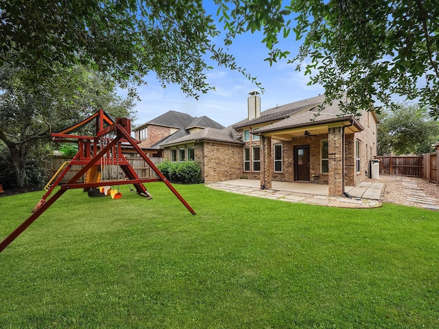 28111 Harper Creek Ln, Katy, TX 77494 - back of house with a playground, a patio, a fenced backyard, a chimney, and brick siding