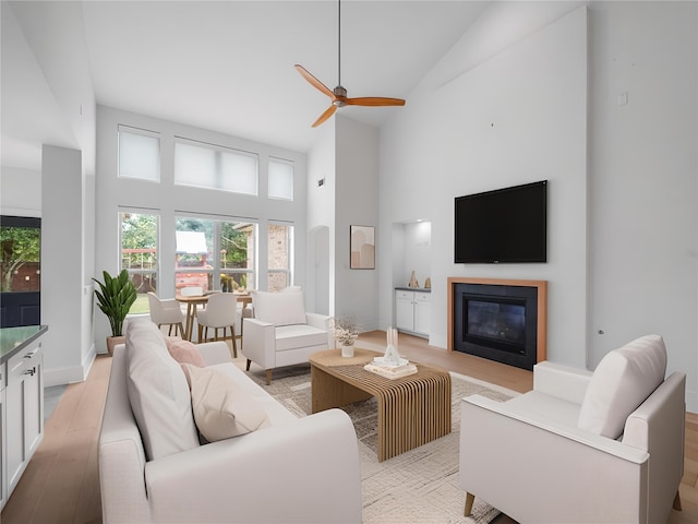 28111 Harper Creek Ln, Katy, TX 77494 - living area featuring high vaulted ceiling, light wood-type flooring, ceiling fan, and a glass covered fireplace