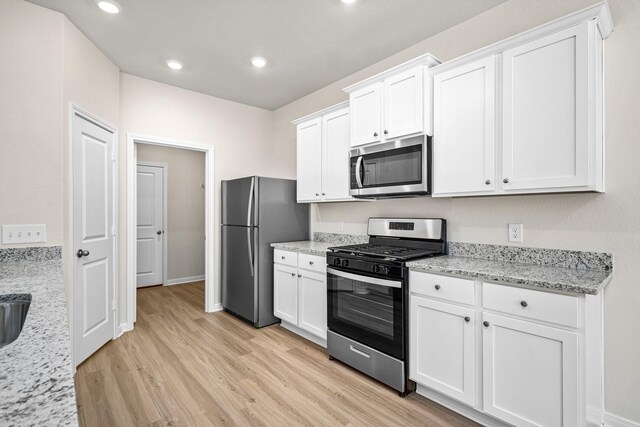 10377 Red Cardinal Dr, Cleveland, TX 77328 - kitchen featuring stainless steel appliances, light wood finished floors, white cabinetry, and recessed lighting