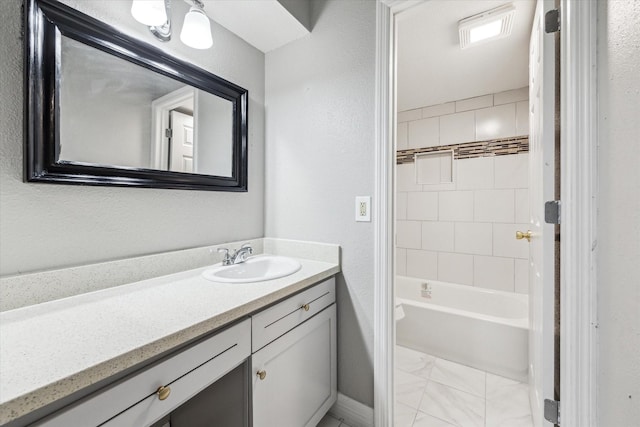 2100 Tanglewilde St Unit 360, Houston, TX 77063 - bathroom featuring vanity, marble look tiles, and  shower combination