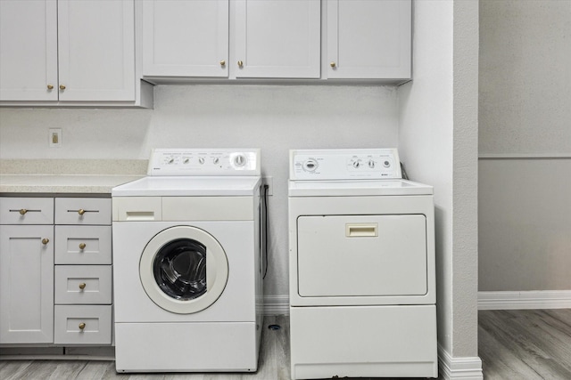 2100 Tanglewilde St Unit 360, Houston, TX 77063 - laundry room featuring washing machine and clothes dryer, light wood-style flooring, and cabinet space