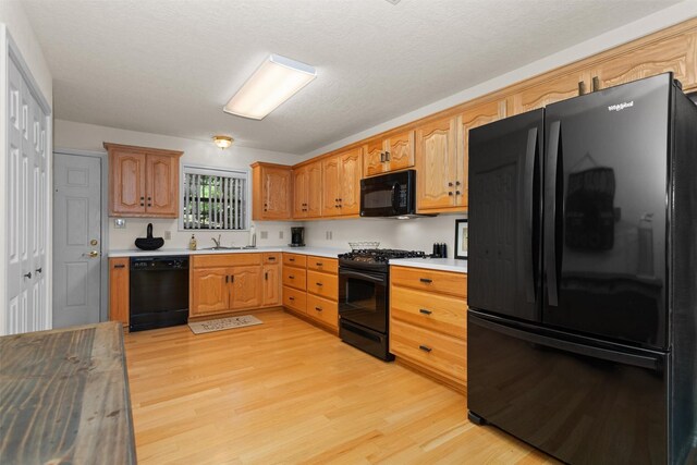 386 Dailey Rd, Crockett, TX 75835 - kitchen with black appliances, light wood-type flooring, and light countertops