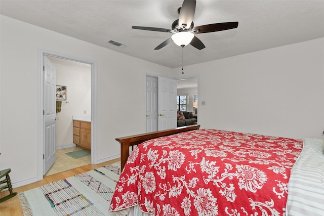 386 Dailey Rd, Crockett, TX 75835 - bedroom with light wood-style floors, a ceiling fan, and ensuite bathroom