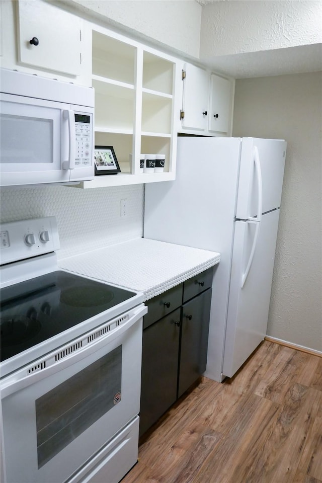 6410 Del Monte Dr Unit 118, Houston, TX 77057 - kitchen with white appliances, light wood-type flooring, light countertops, white cabinets, and open shelves