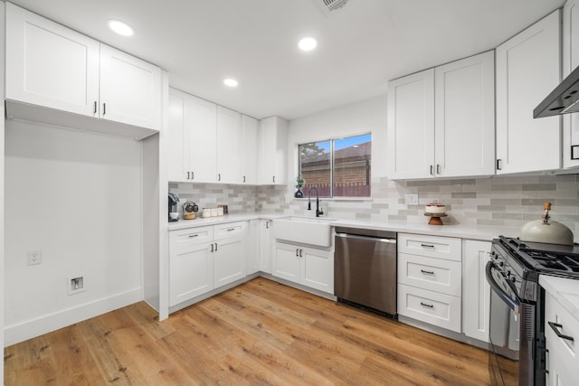 9030 Tanager St, Houston, TX 77036 - kitchen featuring stainless steel dishwasher, black gas range, light countertops, decorative backsplash, and white cabinetry