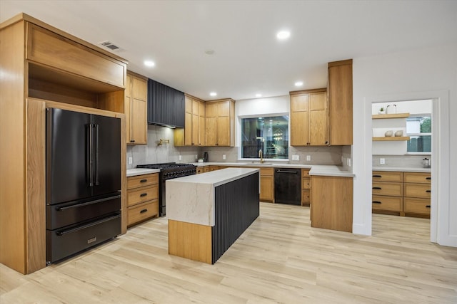 5005 Chestnut St, Bellaire, TX 77401 - kitchen featuring black appliances, light countertops, light wood-style floors, tasteful backsplash, and recessed lighting