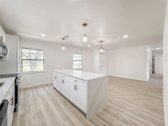 14214 Morinscott, Houston, TX 77049 - kitchen featuring white cabinets, a kitchen island, light wood-type flooring, pendant lighting, and recessed lighting