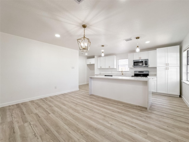 14214 Morinscott, Houston, TX 77049 - kitchen with stainless steel microwave, electric range oven, white cabinets, light wood-style flooring, and a chandelier