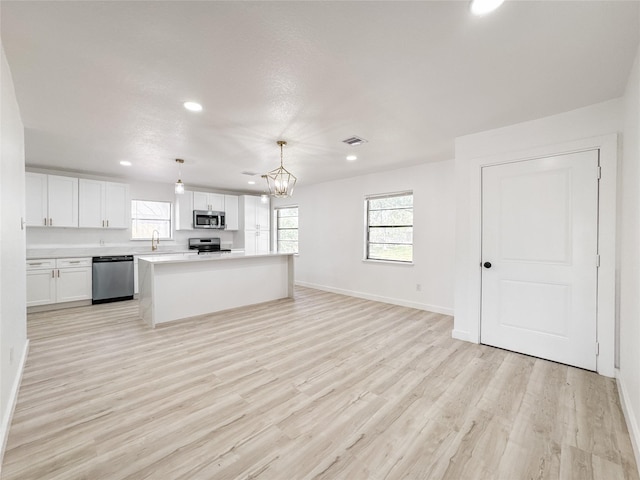 14214 Morinscott, Houston, TX 77049 - kitchen with appliances with stainless steel finishes, recessed lighting, white cabinetry, light wood-style flooring, and light countertops