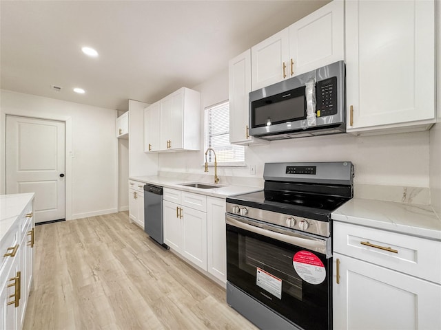 14214 Morinscott, Houston, TX 77049 - kitchen with stainless steel appliances, white cabinetry, light wood-type flooring, recessed lighting, and light stone counters