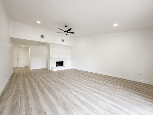 14214 Morinscott, Houston, TX 77049 - unfurnished living room featuring ceiling fan, light wood finished floors, a fireplace, and recessed lighting