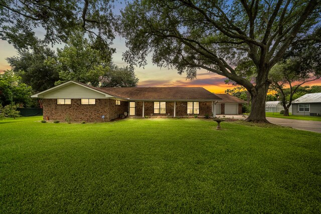 8105 Miller Dr, Hitchcock, TX 77563 - ranch-style house featuring concrete driveway, a front lawn, and brick siding