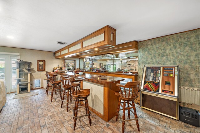 8105 Miller Dr, Hitchcock, TX 77563 - kitchen with brick patterned flooring, wallpapered walls, a peninsula, dark countertops, and brown cabinets