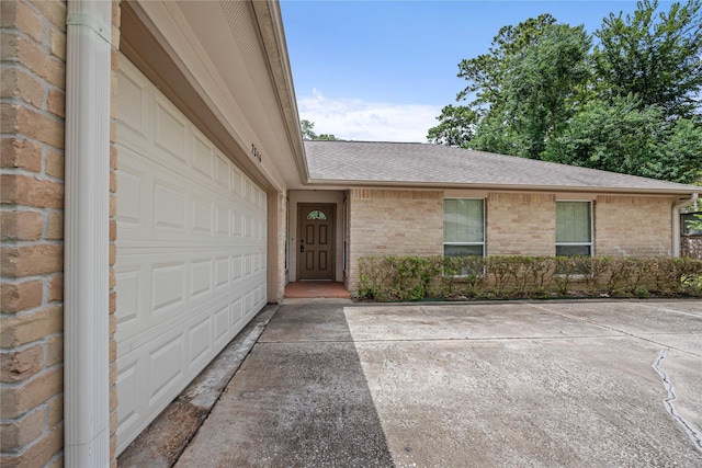 2546 Anzalone Dr, Spring, TX 77373 - view of exterior entry with a shingled roof, brick siding, and concrete driveway