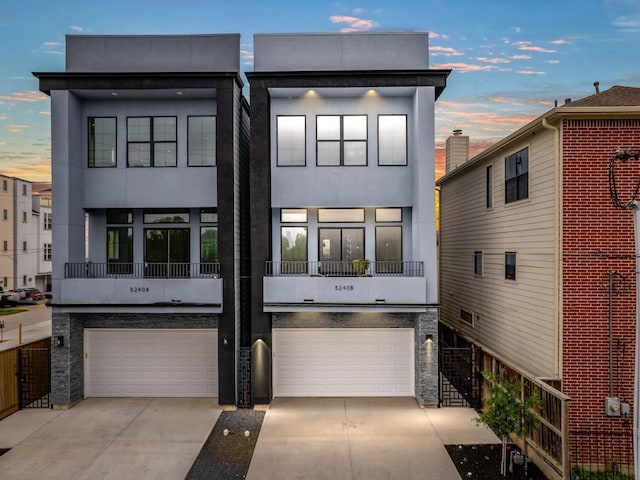 5240 Cornish Unit B, Houston, TX 77007 - back of property at dusk featuring stucco siding, a garage, and driveway