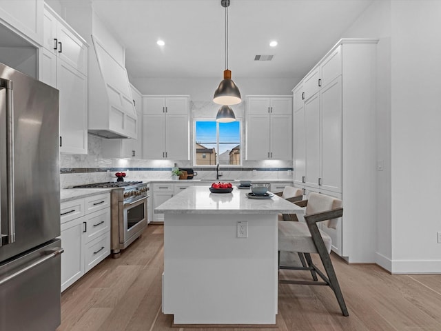 5240 Cornish Unit B, Houston, TX 77007 - kitchen with high end appliances, backsplash, custom range hood, white cabinetry, and recessed lighting