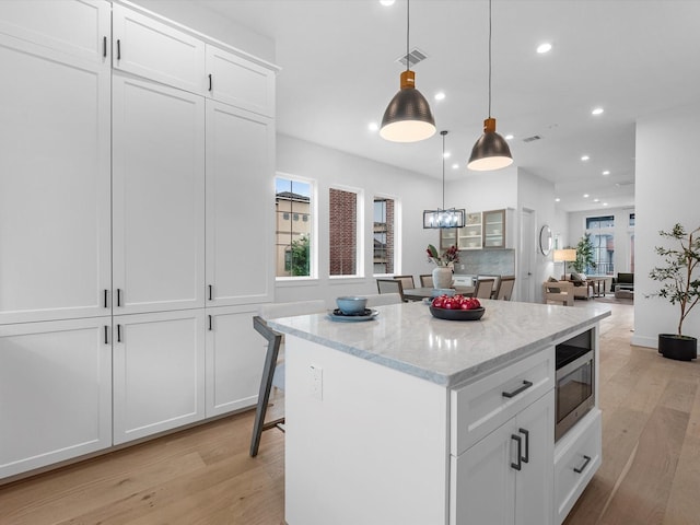 5240 Cornish Unit B, Houston, TX 77007 - kitchen featuring recessed lighting, light wood-style flooring, white cabinetry, a center island, and plenty of natural light