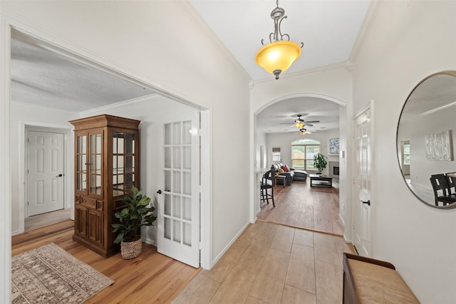 5207 Caprock Dr, Pearland, TX 77584 - foyer entrance featuring a ceiling fan, arched walkways, crown molding, and light wood finished floors