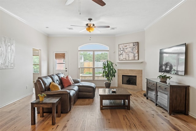 5207 Caprock Dr, Pearland, TX 77584 - living area with a ceiling fan, light wood finished floors, a tiled fireplace, and crown molding