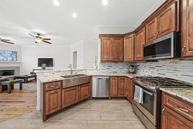 5207 Caprock Dr, Pearland, TX 77584 - kitchen with appliances with stainless steel finishes, a peninsula, crown molding, backsplash, and open floor plan