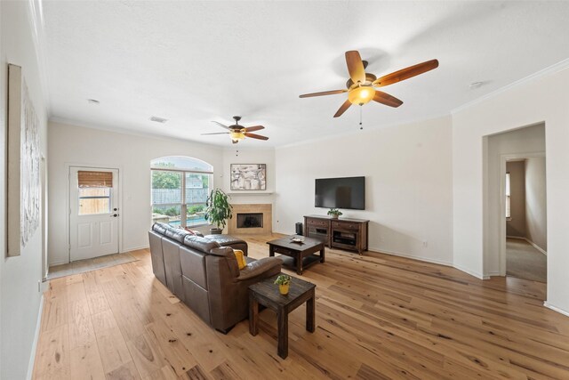 5207 Caprock Dr, Pearland, TX 77584 - living area with ornamental molding, a ceiling fan, light wood finished floors, and a fireplace with flush hearth