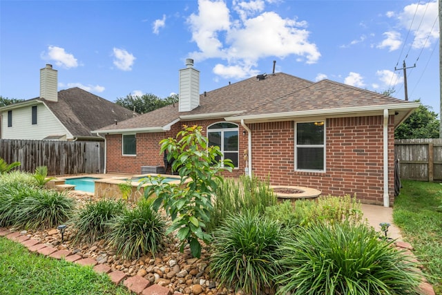 5207 Caprock Dr, Pearland, TX 77584 - back of property with brick siding, a shingled roof, and a chimney