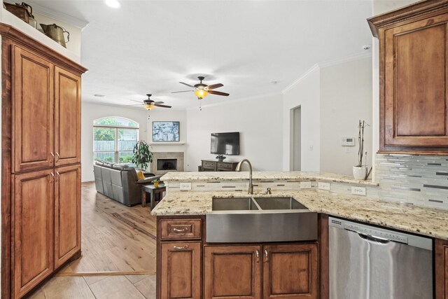 5207 Caprock Dr, Pearland, TX 77584 - kitchen with stainless steel dishwasher, a peninsula, a fireplace, a ceiling fan, and light stone counters