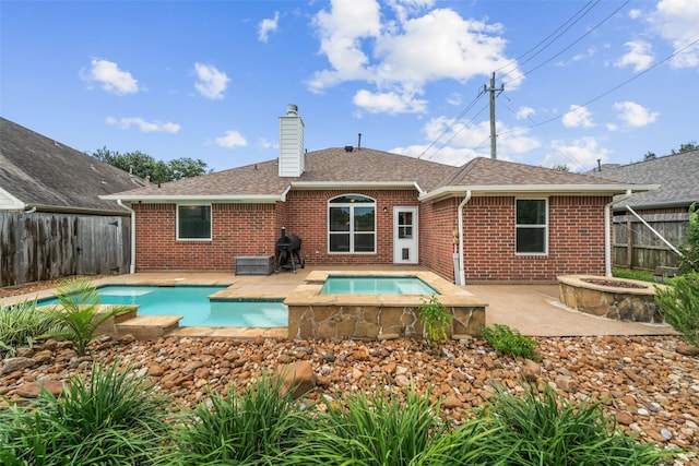 5207 Caprock Dr, Pearland, TX 77584 - back of house featuring an in-ground hot tub, brick siding, a chimney, a patio, and a fenced backyard