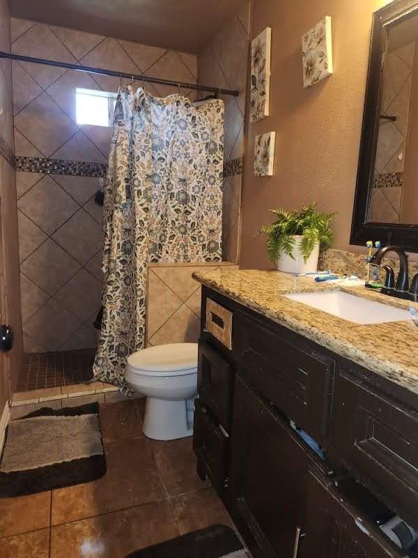 1902 July St, Houston, TX 77093 - full bathroom featuring vanity, a tile shower, and tile patterned floors